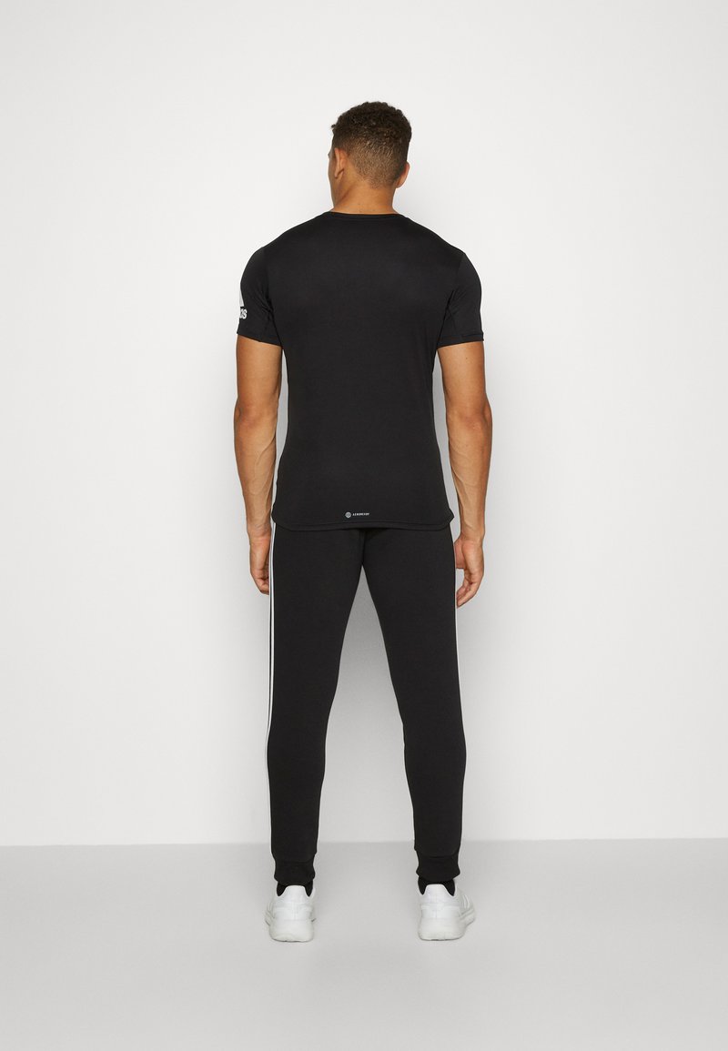 adidas Sportswear adidas Sportswear ESSENTIALS TAPERED CUFF 3 STRIPES PANTS - Tracksuit bottoms - black white Speichern exportieren