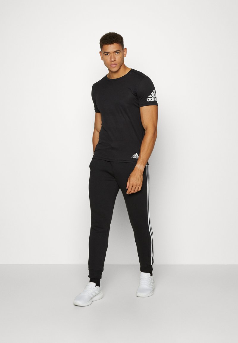 adidas Sportswear adidas Sportswear ESSENTIALS TAPERED CUFF 3 STRIPES PANTS - Tracksuit bottoms - black white Speichern exportieren